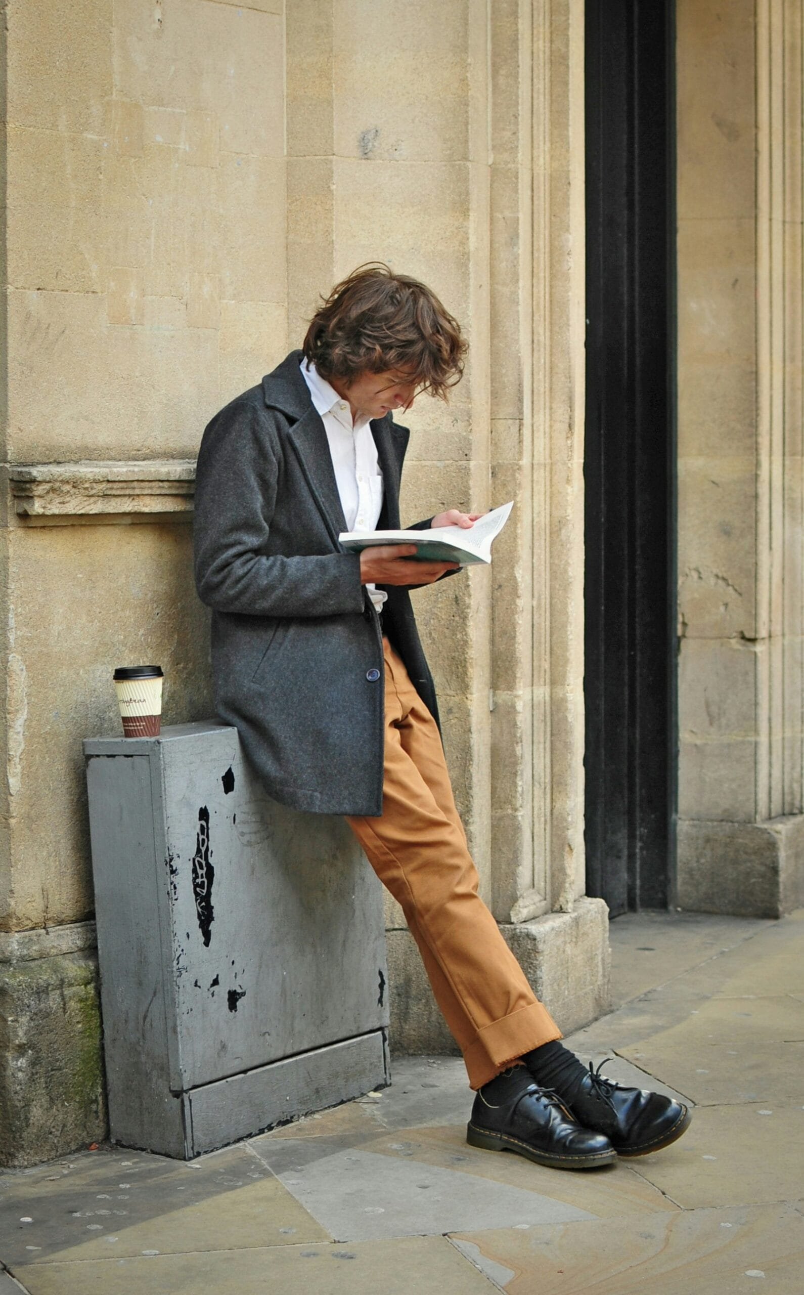 man sitting beside cup of coffee